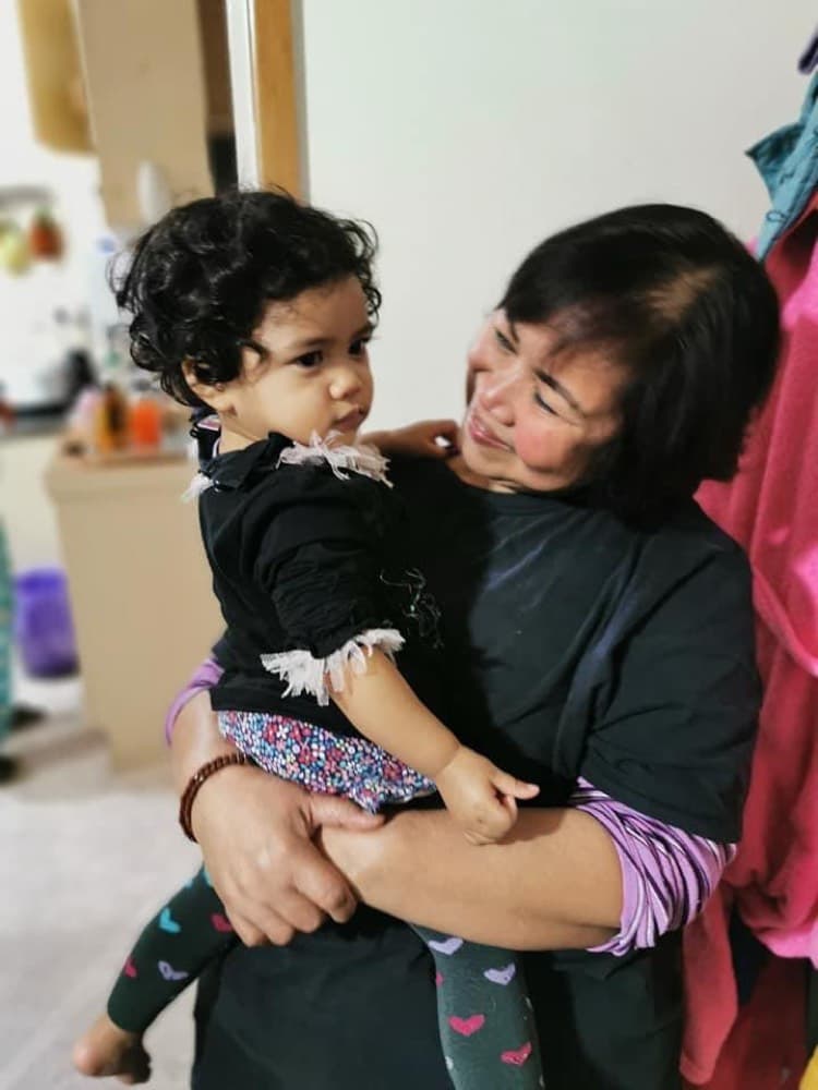 Caregiver holding a young child at home